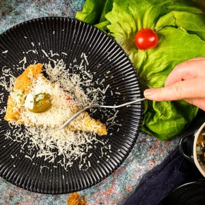 Delicious focaccia slice topped with cheese and olives on a stylish plate.