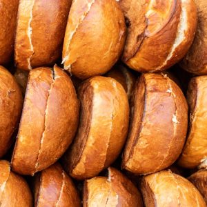Close-up of golden brown hamburger buns neatly stacked, showcasing their delicious texture.