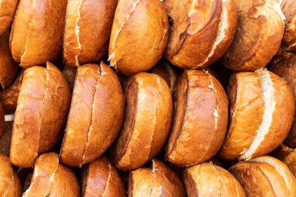 Close-up of golden brown hamburger buns neatly stacked, showcasing their delicious texture.